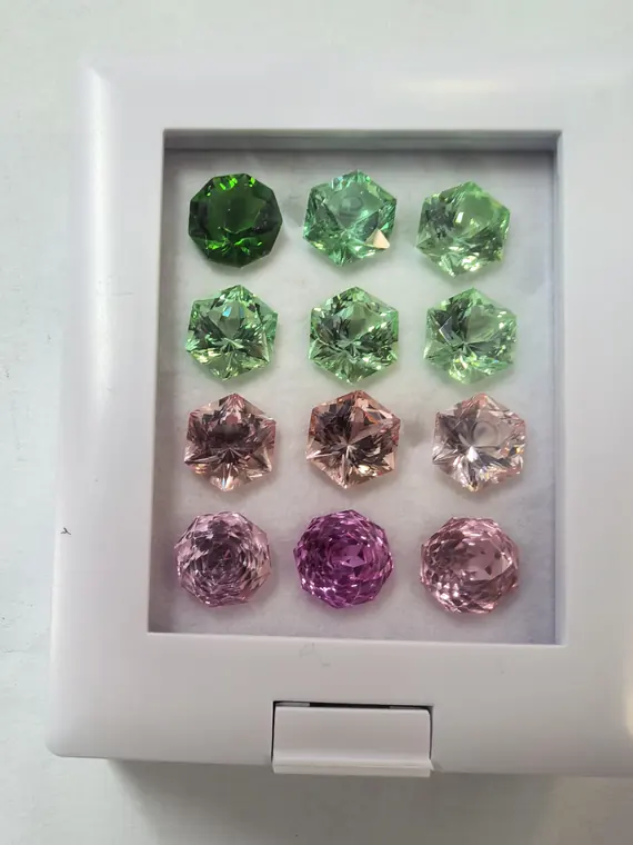 Gemformia green and pink specialty-cut gemstone samples arranged in a display box