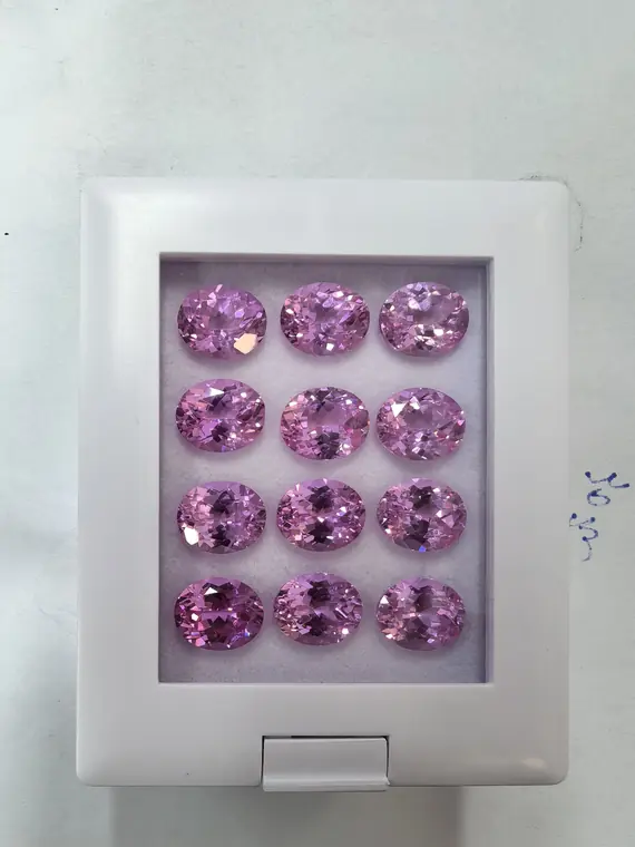 Gemformia pink oval-cut gemstone samples arranged in a display box
